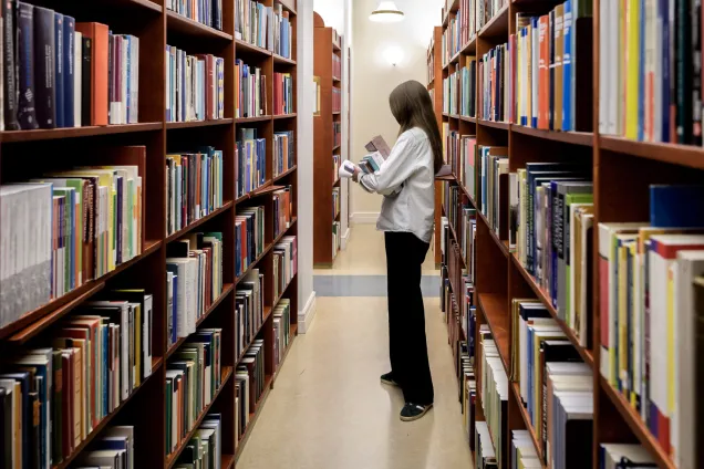 A student searching for books in the library.Photo.