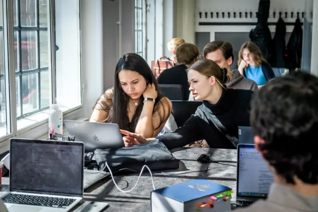 Två studenter sitter tillsammans och studerar. Foto.