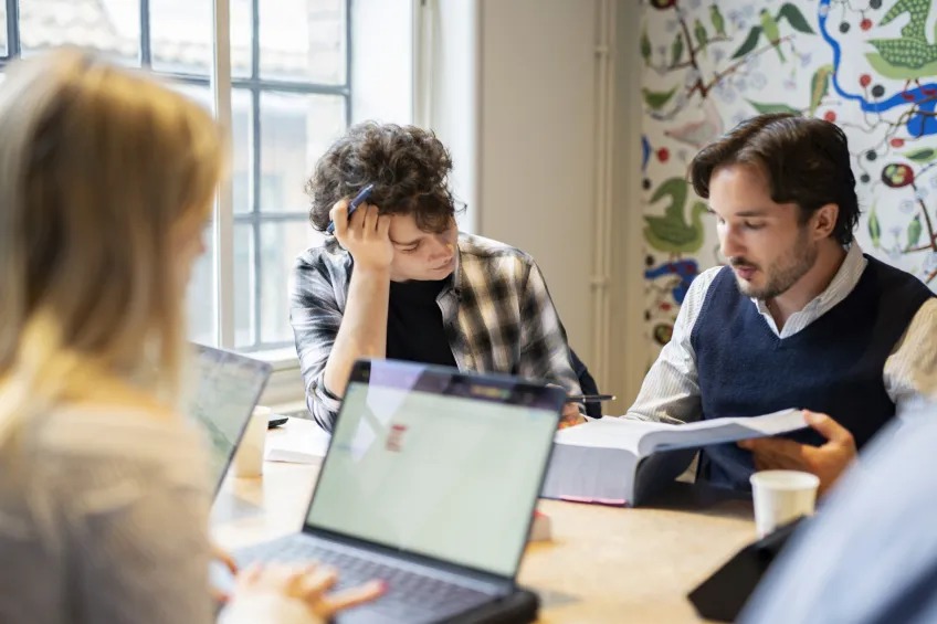 Three students studying in a group room. Photo.